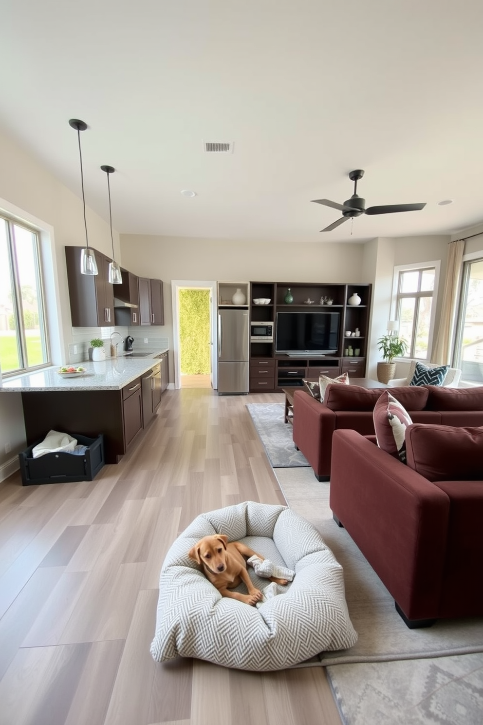 A modern kitchen and family room combo designed for family gatherings. The kitchen features an island with bar seating, stainless steel appliances, and quartz countertops, while the family room boasts a cozy sectional sofa and a large entertainment unit. In the corner, a designated pet area includes a stylish dog bed and storage for toys. The space is filled with natural light from large windows, and the color palette combines warm neutrals with pops of color for a welcoming atmosphere.