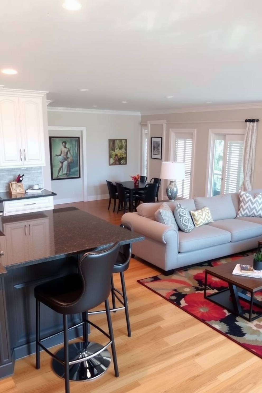 A cozy kitchen family room combo featuring an open layout. The kitchen island is topped with a dark granite surface and surrounded by stylish bar stools. In the family room, a large sectional sofa is positioned around a modern coffee table. A vibrant area rug anchors the seating area, creating a warm and inviting atmosphere.