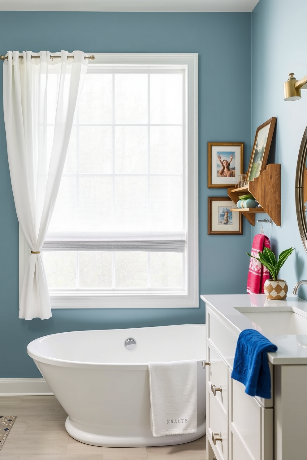 A stylish bathroom designed for Labor Day celebrations features a freestanding soaking tub positioned beneath a large window with sheer white curtains. The walls are painted in a soft blue hue, creating a serene atmosphere, while a rustic wooden shelf displays framed artwork that adds personality and charm to the space. The vanity is adorned with a sleek white countertop and a round mirror with a brushed nickel finish. Decorative elements like a small potted plant and plush towels in vibrant colors complete the look, making the bathroom inviting and festive for the holiday.