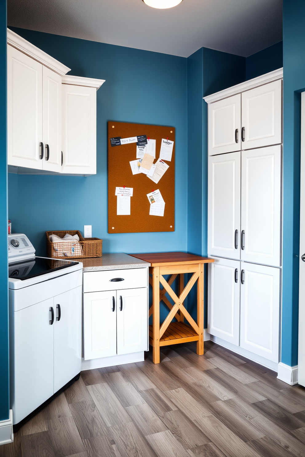 A cozy laundry room designed for functionality and style. The walls are painted in a soft blue hue, complemented by white cabinetry that provides ample storage. A large bulletin board is mounted above a wooden folding table, perfect for organizing notes and reminders. The floor features durable vinyl planks in a light gray finish, making cleanup easy and efficient.