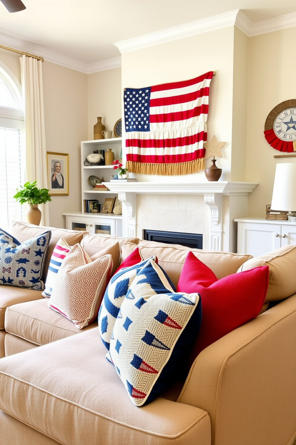 Cozy red white and blue throw pillows are arranged on a plush sectional sofa in a bright and inviting living room. The walls are adorned with patriotic artwork and a woven American flag hangs above the fireplace, creating a festive atmosphere for Labor Day celebrations.