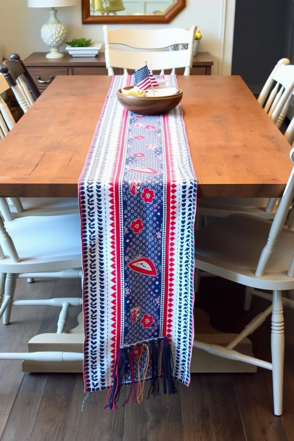 A vibrant table runner adorned with red, white, and blue patterns stretches across a rustic wooden dining table. Surrounding the table, mismatched chairs in soft neutrals create a cozy and inviting atmosphere for a festive Labor Day gathering.