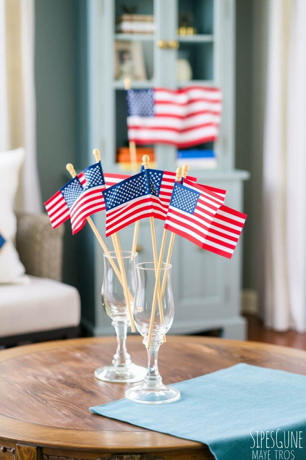 Mini American flags are arranged in elegant glass vases placed on a rustic wooden table. The vibrant colors of the flags add a festive touch to the cozy space, celebrating Labor Day with charm. For small space decorating ideas, consider using multifunctional furniture that maximizes usability without sacrificing style. Incorporate light colors and mirrors to create an illusion of openness and airiness in the compact area.