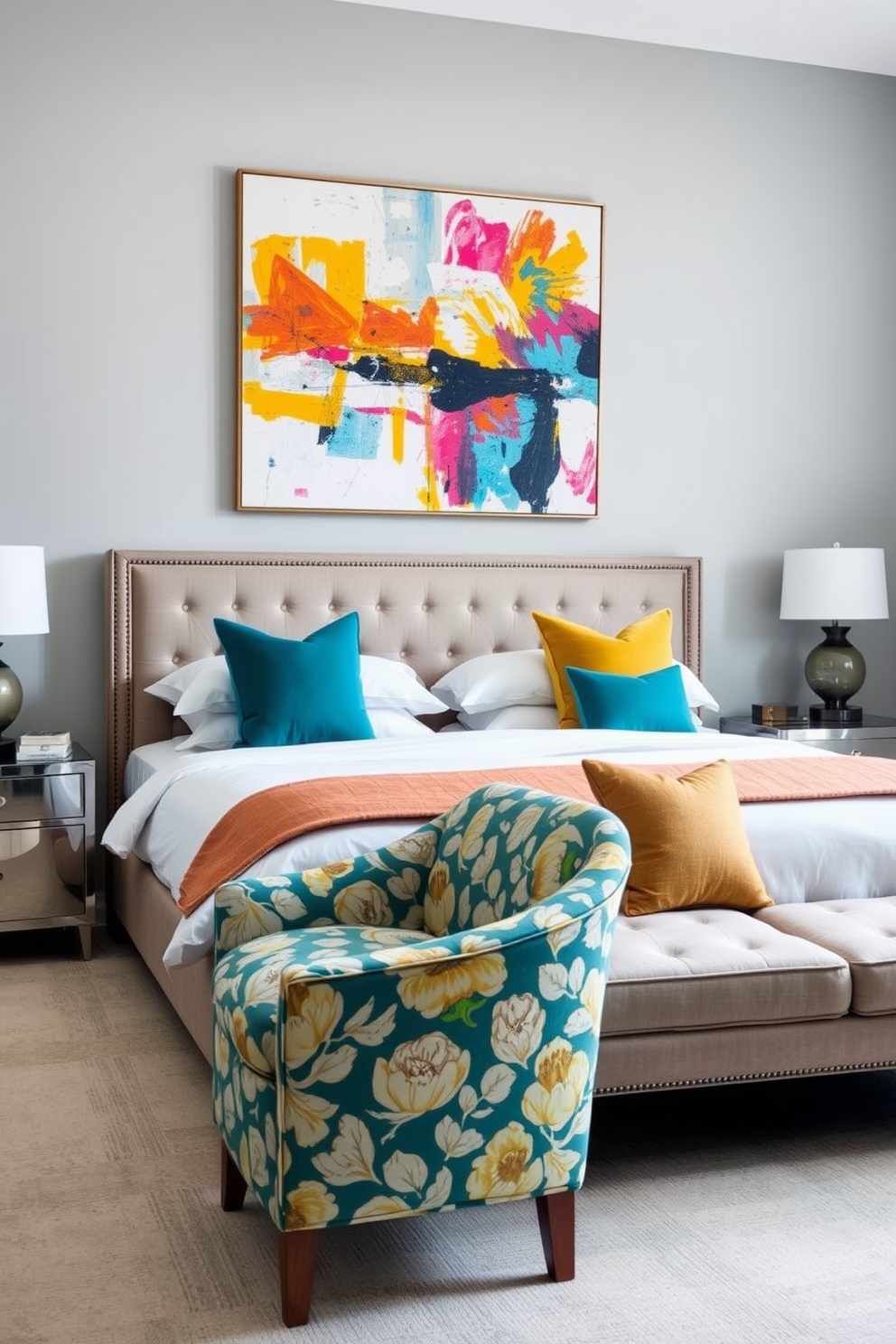 A spacious bedroom featuring a king-sized bed with a plush headboard in a neutral tone. The bedding is adorned with vibrant throw pillows in shades of teal and mustard, adding a lively contrast to the soft gray walls. A stylish armchair sits in the corner, upholstered in a bold floral fabric that complements the decor. A large abstract painting with bright colors hangs above the bed, creating a focal point that energizes the space.