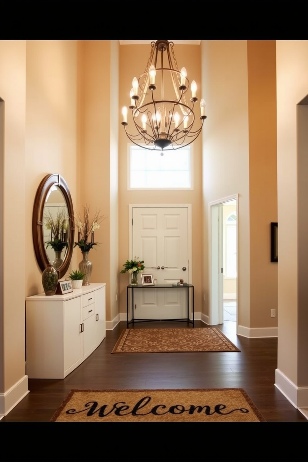 A personalized welcome mat greets guests at the entrance, adding a touch of charm to the space. The large entryway features a stunning chandelier that hangs from a high ceiling, illuminating the area with warm light. On one side, a stylish console table is adorned with decorative items and fresh flowers. The walls are painted in a soft beige hue, complemented by a statement mirror that enhances the sense of space and light.