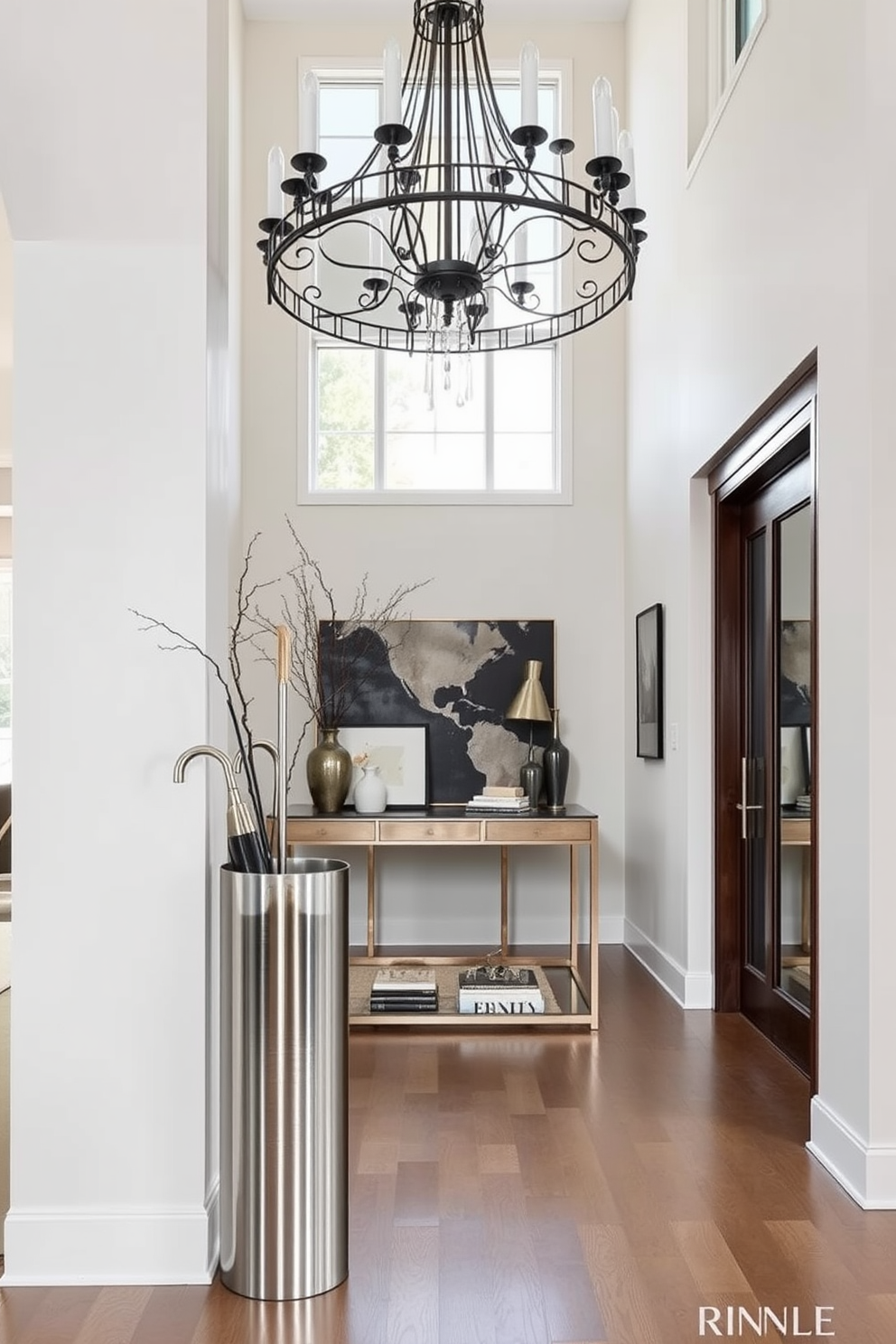 A grand entryway features high ceilings adorned with intricate crown molding that adds elegance and sophistication. The space is illuminated by a stunning chandelier that hangs gracefully, casting a warm glow over the polished hardwood floor. To the left, a stylish console table is complemented by a large decorative mirror, creating an inviting focal point. Flanking the entryway are tall potted plants that enhance the sense of openness and provide a touch of nature.