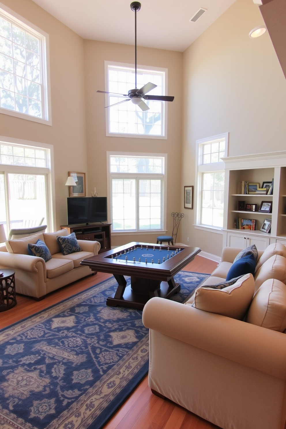 A spacious family room designed for comfort and entertainment. The focal point is a large game table surrounded by plush seating, perfect for family gatherings and game nights. Natural light floods the room through oversized windows, enhancing the warm color palette of soft beige and deep blue accents. A cozy area rug anchors the seating arrangement, while built-in shelves display family photos and games.