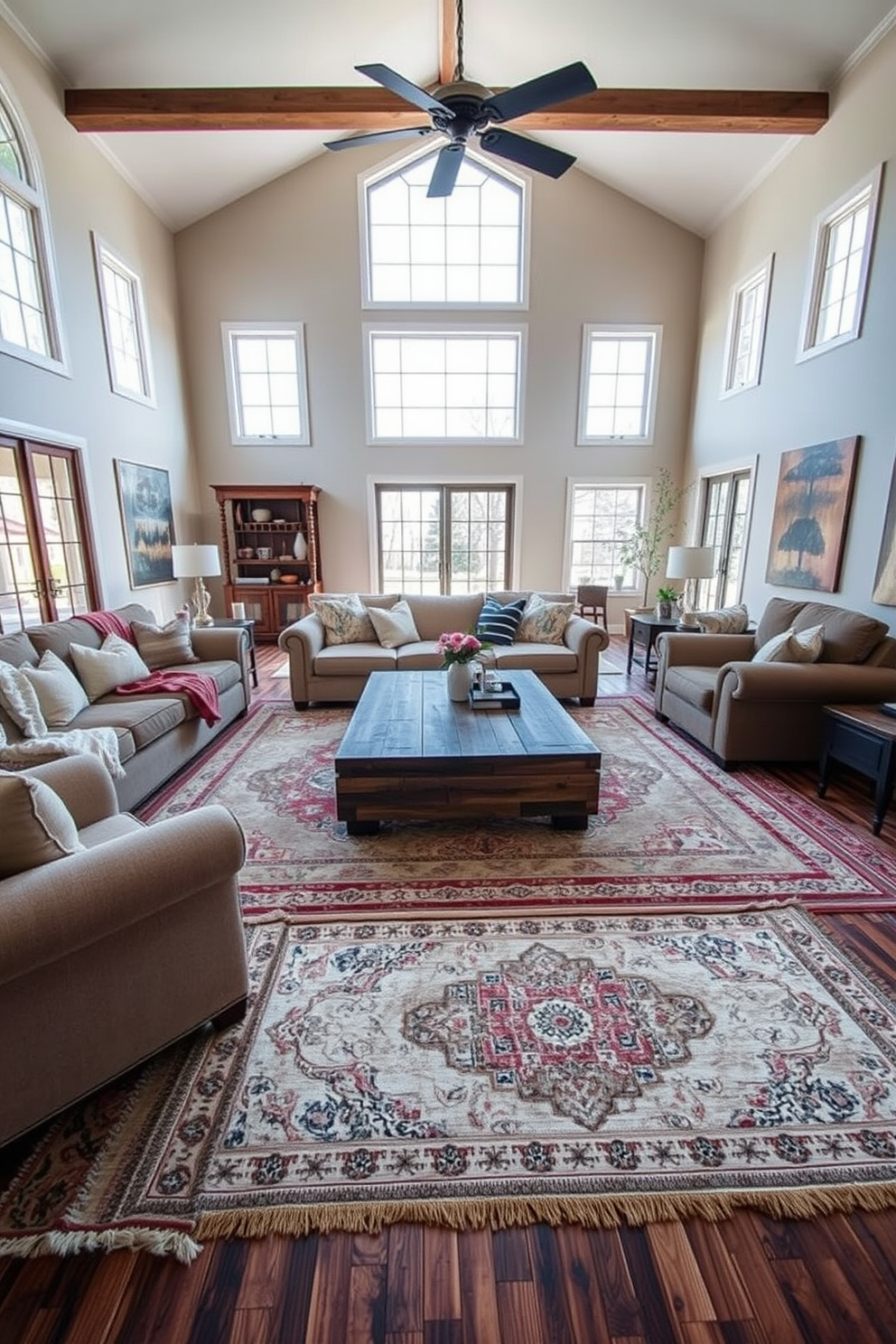 A spacious family room filled with natural light. The floor is adorned with layered rugs in various textures and colors, creating a cozy atmosphere. Comfortable seating arrangements include a large sectional sofa and oversized armchairs. A coffee table made of reclaimed wood sits at the center, surrounded by decorative pillows and throws.