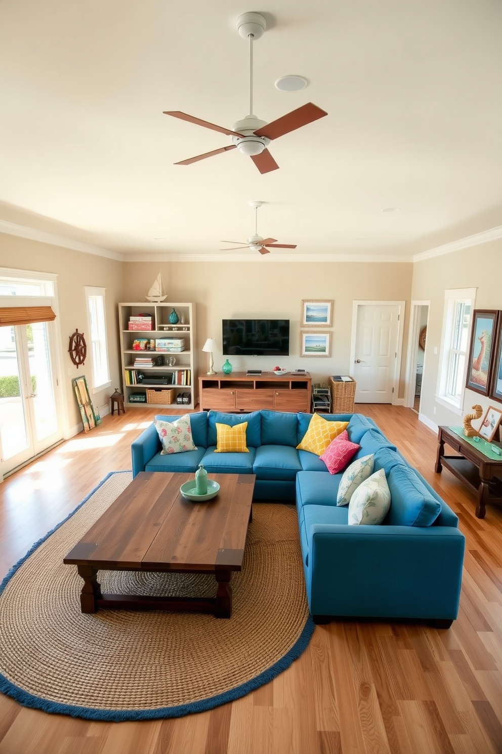 A coastal-themed game room filled with natural light. The walls are painted in a soft sandy beige, and the flooring is a light oak wood that evokes a beachside atmosphere. In the center, a large sectional sofa in ocean blue is surrounded by colorful throw pillows. A rustic wooden coffee table sits atop a woven jute rug, adding to the relaxed beach vibe. On one side, a wall-mounted entertainment unit displays beach-themed decor and games. Nautical accents like a ship wheel and framed beach prints complete the inviting and playful space.