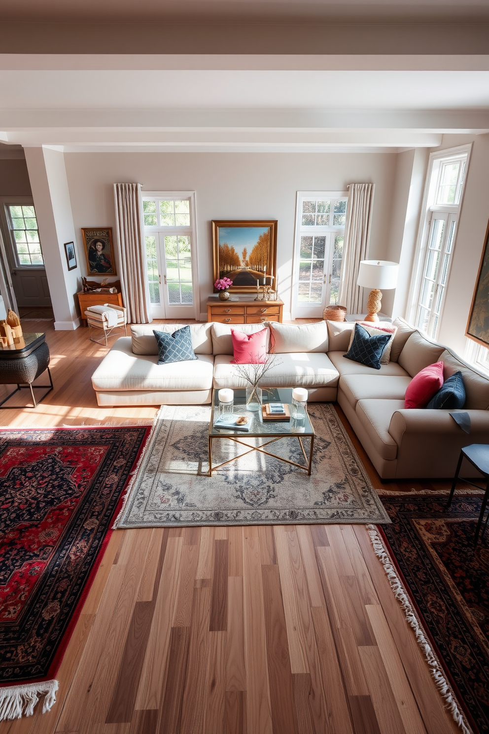 A spacious living room filled with natural light. The floor is adorned with layered rugs in varying textures and colors, creating a cozy and inviting atmosphere. A large sectional sofa in a neutral tone anchors the room, complemented by vibrant accent pillows. A stylish coffee table sits at the center, surrounded by elegant side tables and decorative accessories.