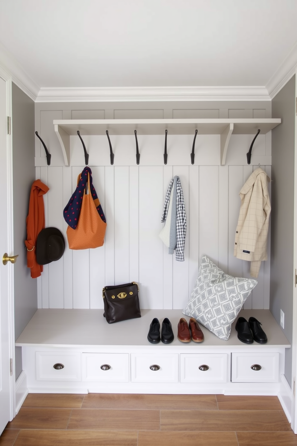 A spacious mudroom features functional hooks at varying heights to accommodate family members of all ages. The design includes a built-in bench with storage underneath, ensuring a clutter-free space for shoes and outdoor gear.