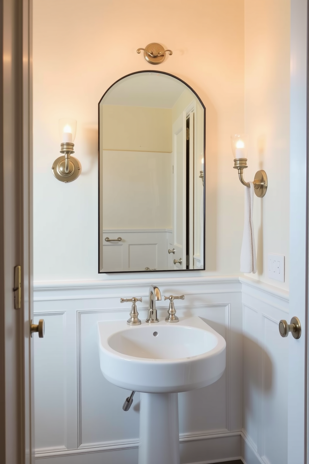 A stylish powder room featuring elegant sconces that provide warm ambient lighting. The walls are adorned with a soft pastel color, complemented by a chic, oversized mirror above a sleek pedestal sink.