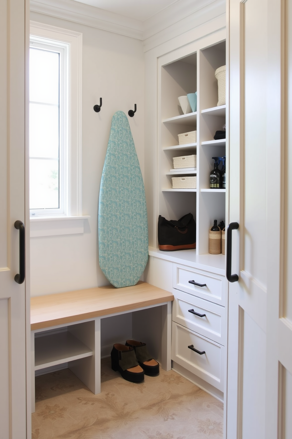 A functional laundry mudroom features an integrated ironing board seamlessly built into the cabinetry for convenience. The space includes ample storage with custom shelving and a stylish bench for easy access to shoes and bags.