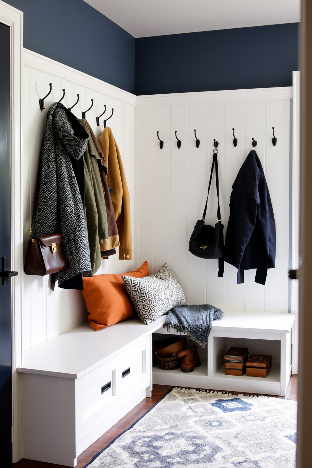 A functional mudroom featuring wall hooks for easy coat access. The space includes a built-in bench with storage underneath and a stylish area rug to add warmth.