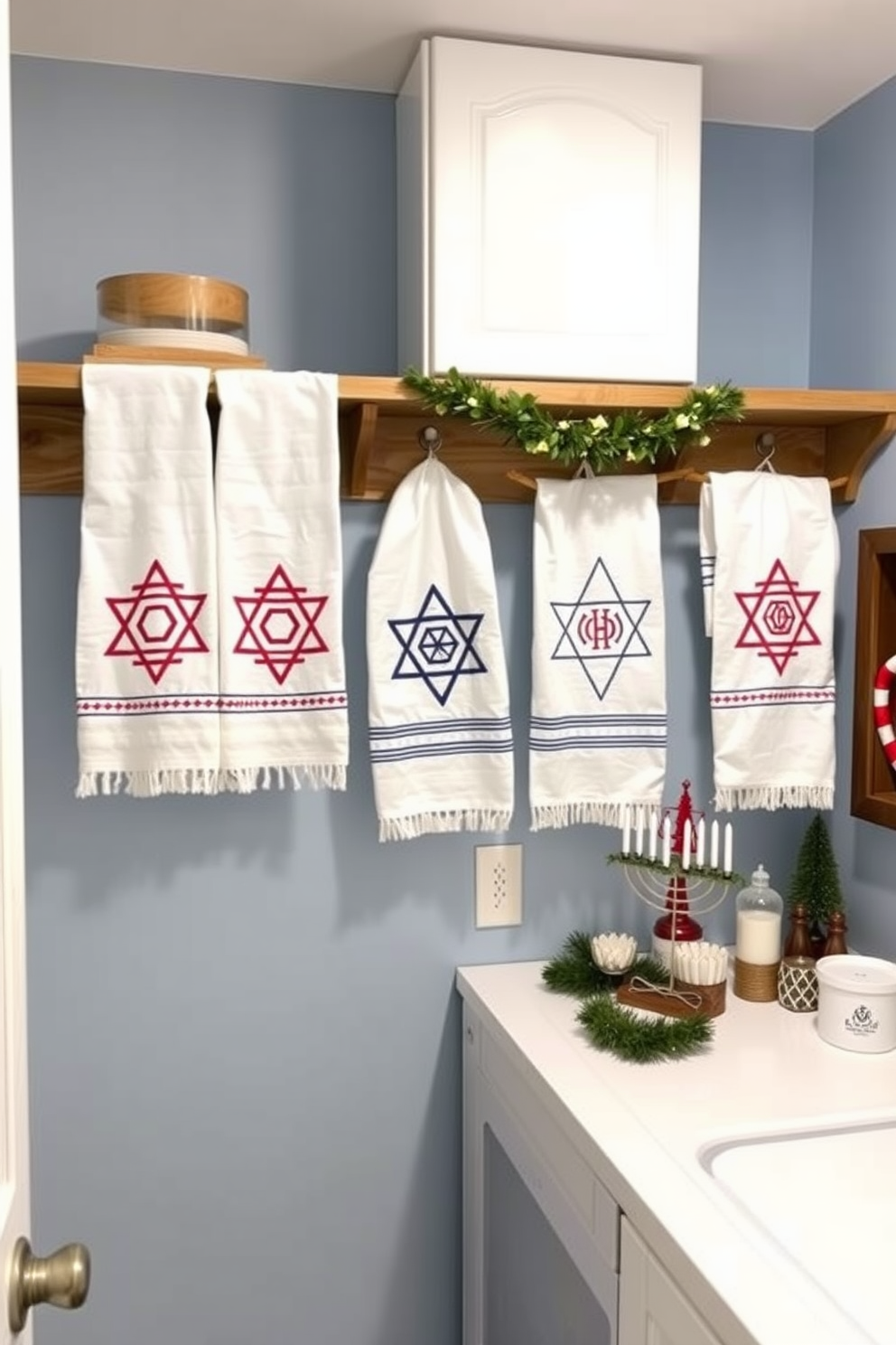 A cozy laundry room decorated for Hanukkah. Decorative towels featuring traditional Hanukkah motifs are neatly arranged on a wooden shelf, adding a festive touch to the space. The walls are painted in a soft blue hue, creating a calm atmosphere. A small menorah sits on the countertop, surrounded by other seasonal decorations to enhance the holiday spirit.