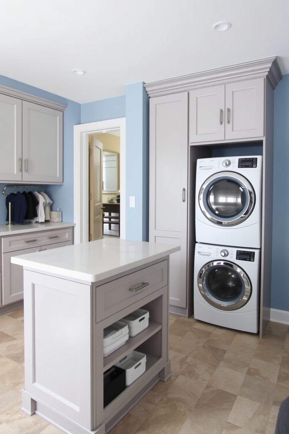 A spacious laundry room featuring a multi-functional island designed for folding clothes. The island is topped with a sleek quartz surface and includes built-in storage compartments for laundry essentials. Adjacent to the island, there is a stacked washer and dryer unit enclosed in a stylish cabinetry that matches the room's color scheme. The walls are painted in a soft blue hue, and the floor is adorned with durable, water-resistant tiles for easy maintenance.