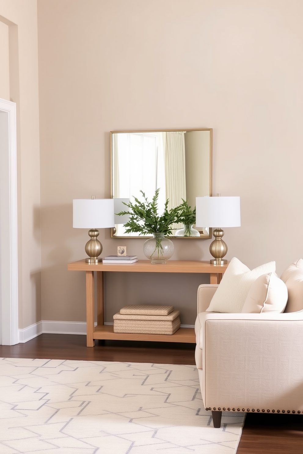 A serene living room entryway features a soft beige sofa adorned with plush cream cushions. The walls are painted in a light taupe, complemented by a natural wood console table adorned with a simple vase of greenery. A large area rug with subtle geometric patterns anchors the space, while a pair of sleek, modern lamps flank the console table. A statement mirror hangs above the table, reflecting the soft light that filters through sheer curtains.