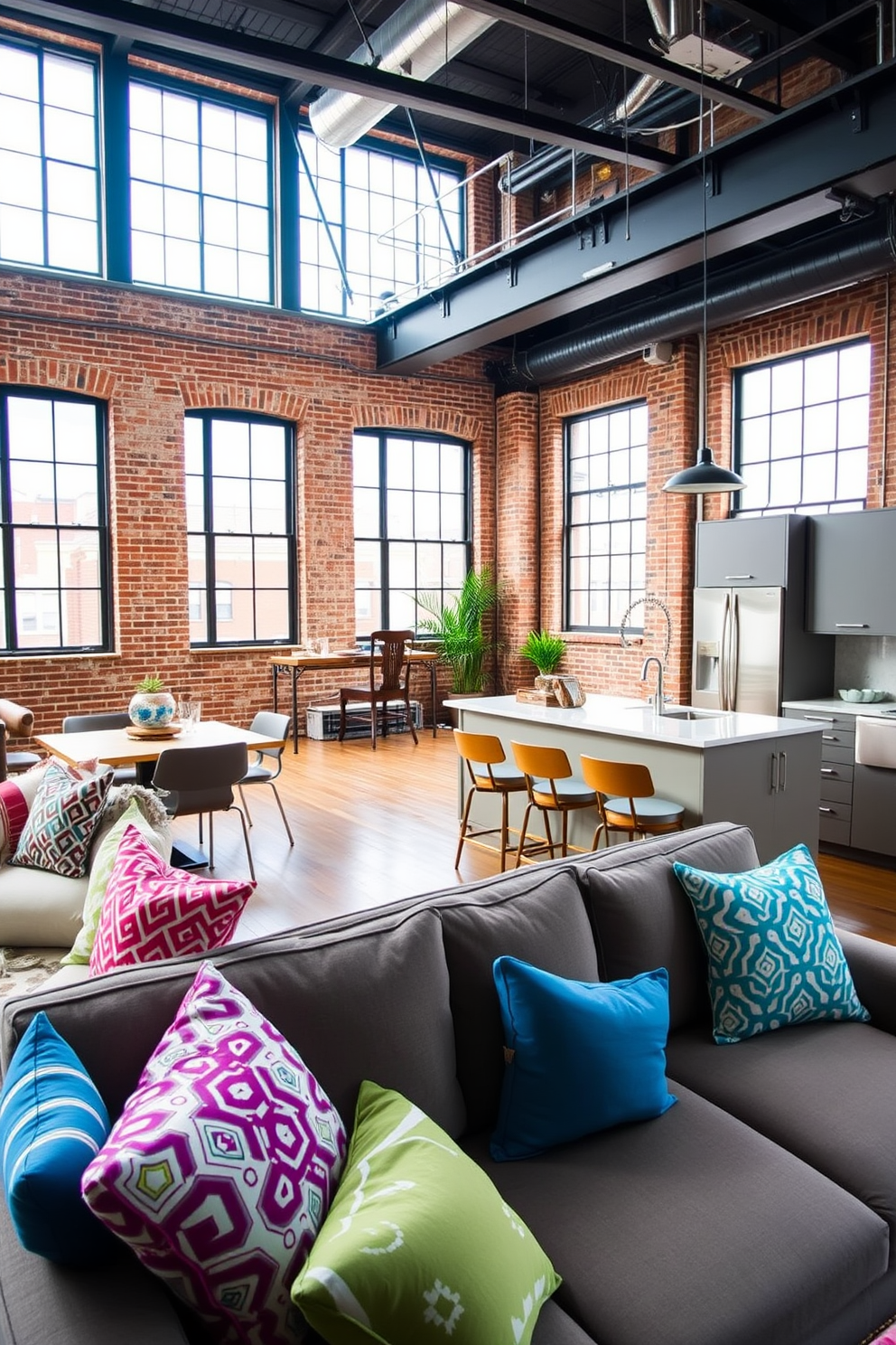 A stylish loft apartment featuring an open floor plan with high ceilings and large windows. The living area is adorned with a mix of bold patterned throw pillows in vibrant colors, adding a pop of personality to the neutral-toned sofa. The kitchen is modern with sleek cabinetry and a large island that doubles as a dining space. Industrial elements like exposed brick walls and metal accents create a trendy yet inviting atmosphere.