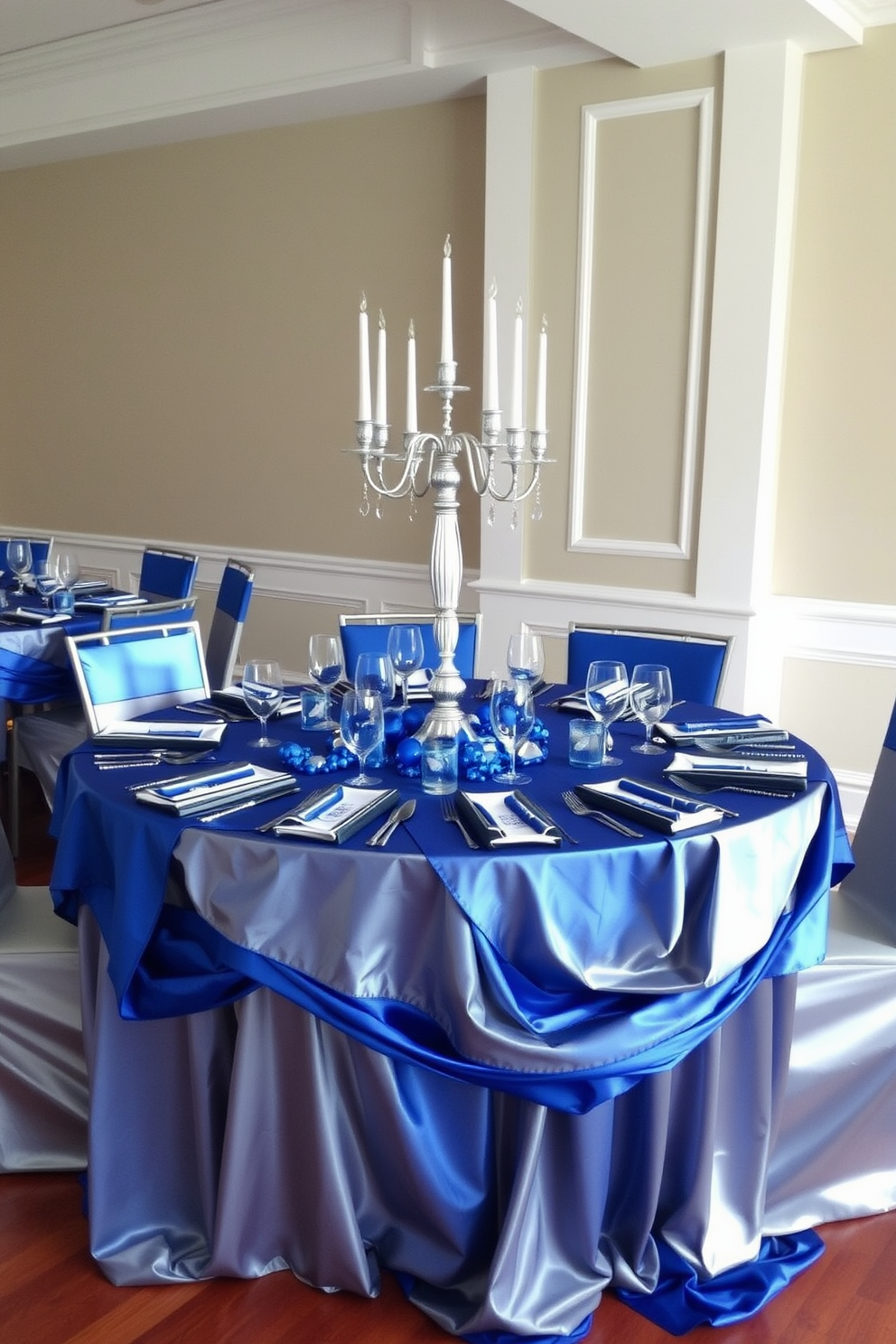 Layered blue and silver table linens create an elegant and festive atmosphere for a Hanukkah celebration. The table is adorned with a beautiful centerpiece featuring silver candlesticks and blue decorative elements that enhance the overall theme.