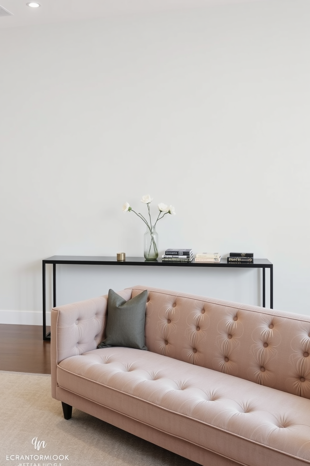 A long living room features a stylish console table positioned behind a plush sofa. The console table is adorned with decorative items such as a vase with fresh flowers and a few carefully arranged books, adding a touch of elegance to the space.