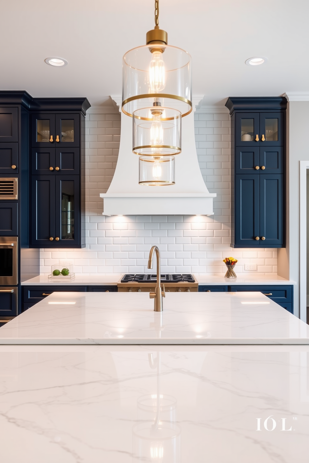 A luxury kitchen featuring a large island with a stunning quartz countertop. Statement lighting fixtures hang above, illuminating the space with a warm glow and enhancing the elegant design. The cabinetry is sleek and modern, finished in a rich navy blue with gold hardware. A stylish backsplash of white subway tiles adds a classic touch, complementing the overall sophistication of the kitchen.