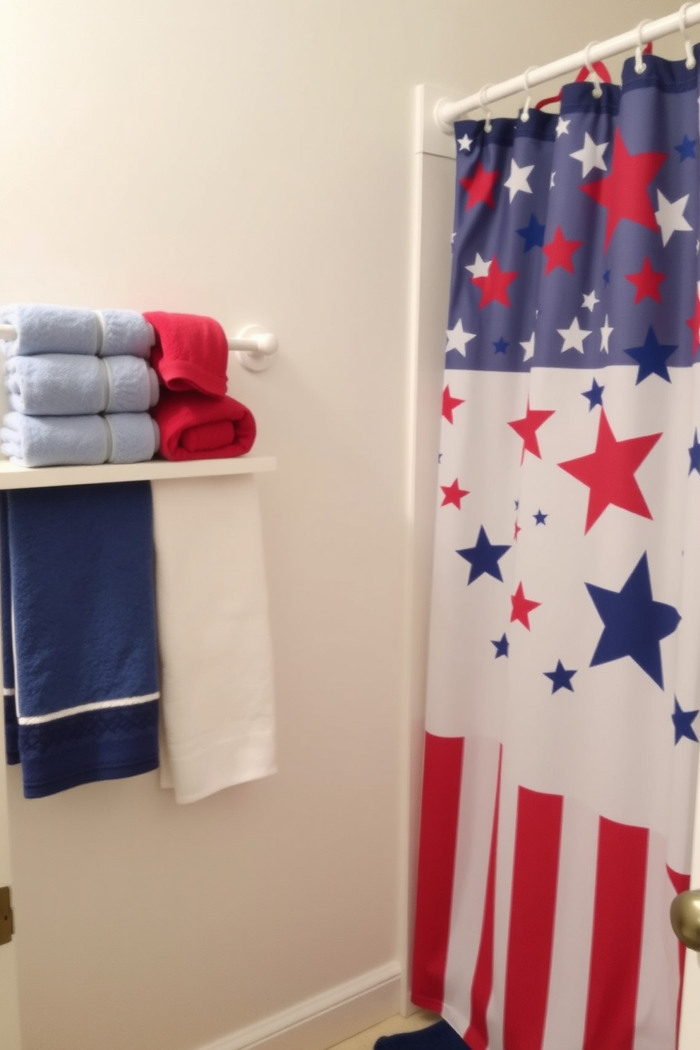 A patriotic bathroom setting featuring red white and blue bath accessories. The towels are arranged neatly on a white towel rack while a decorative shower curtain displays a vibrant stars and stripes pattern.