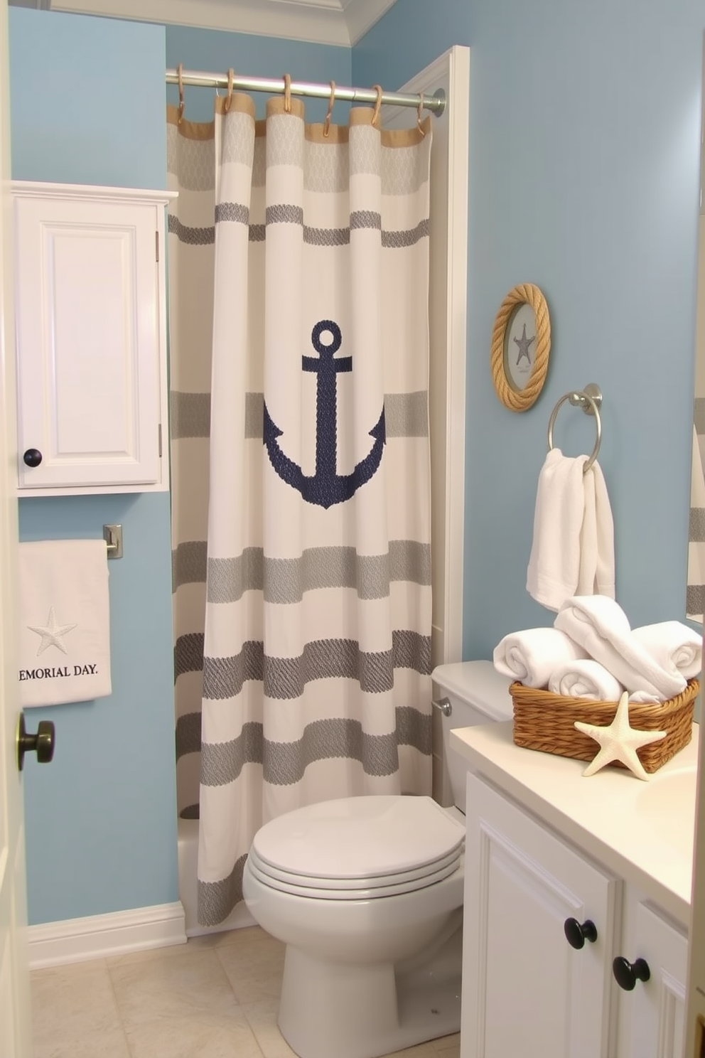 A serene bathroom space featuring nautical rope accents on decor elements. The walls are painted in soft blue, complemented by white cabinetry and decorative items that incorporate natural rope textures. A stylish shower curtain adorned with a nautical theme hangs gracefully, while a woven basket filled with beach towels sits nearby. Subtle starfish and seashell accents are placed on the countertop, enhancing the Memorial Day spirit.