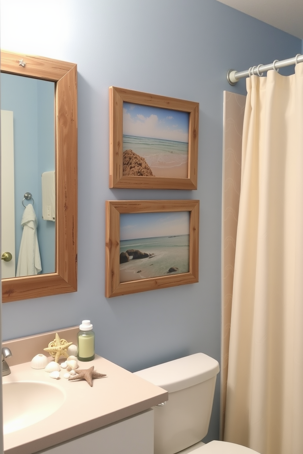 A coastal themed bathroom adorned with picture frames showcasing beach landscapes. The walls are painted in a soft blue hue, and the frames are made of weathered wood, adding a rustic charm to the space. Decorative elements include seashells and starfish arranged on the countertop, complementing the ocean-inspired decor. A light beige shower curtain with subtle wave patterns hangs elegantly, enhancing the overall coastal ambiance.