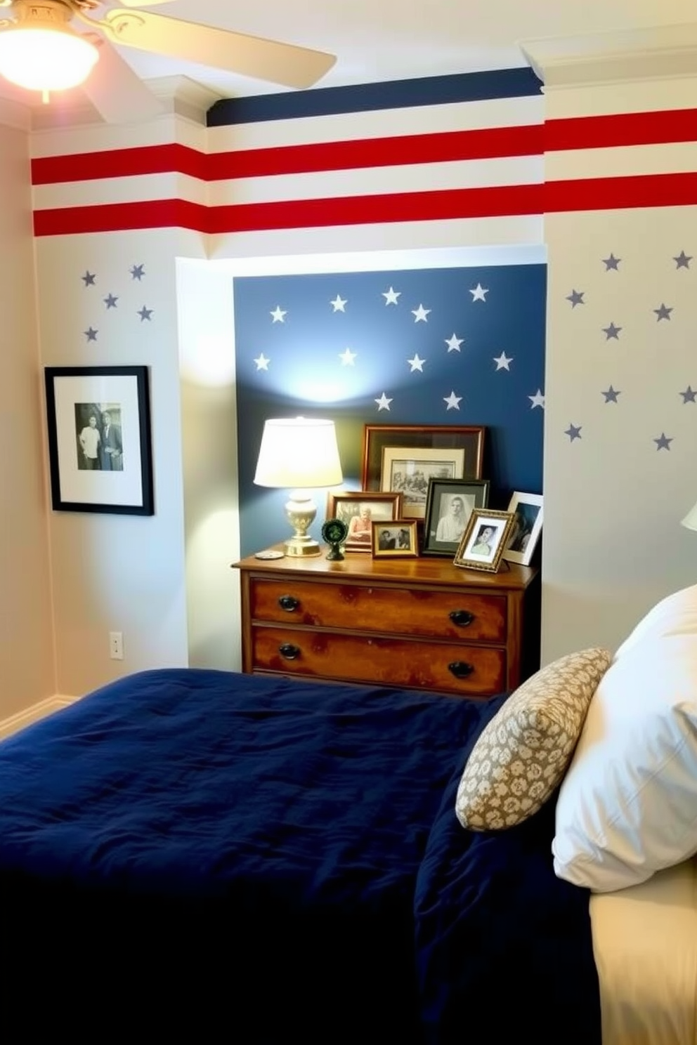 A cozy bedroom featuring a stars and stripes accent wall that adds a patriotic touch to the space. The room is adorned with a plush navy blue bedspread and white pillows, creating a harmonious balance with the bold wall design. A vintage wooden dresser sits opposite the bed, topped with a collection of framed family photos. Soft lighting from a bedside lamp casts a warm glow, enhancing the inviting atmosphere of the room.