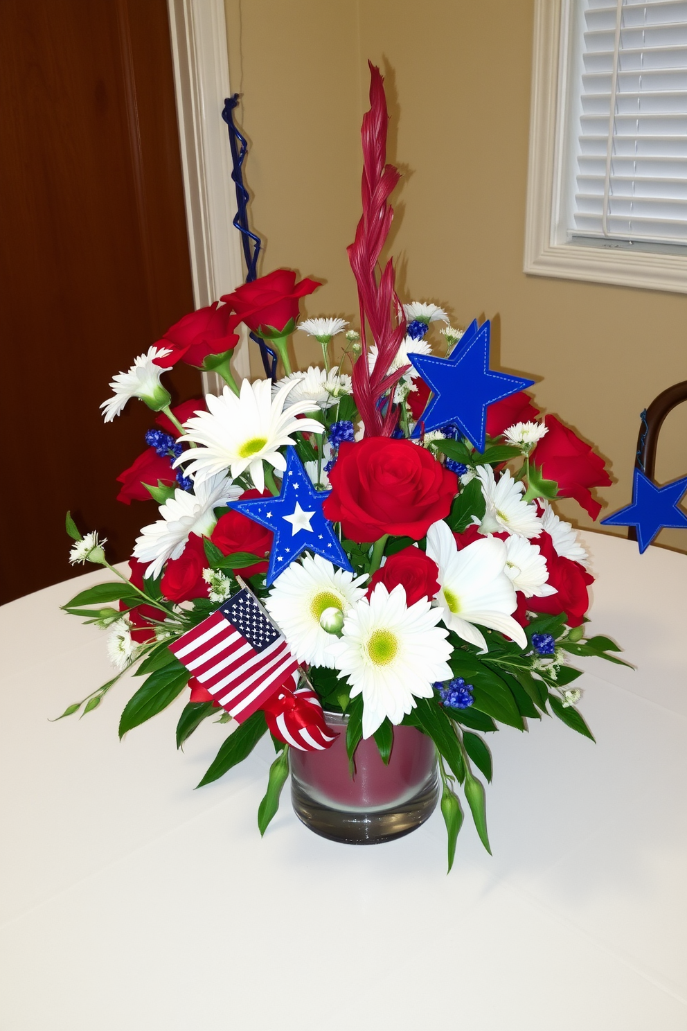 A vibrant table centerpiece for Memorial Day featuring a mix of red white and blue elements. The arrangement includes fresh flowers in shades of red and white, alongside decorative stars and stripes accents to celebrate the holiday.