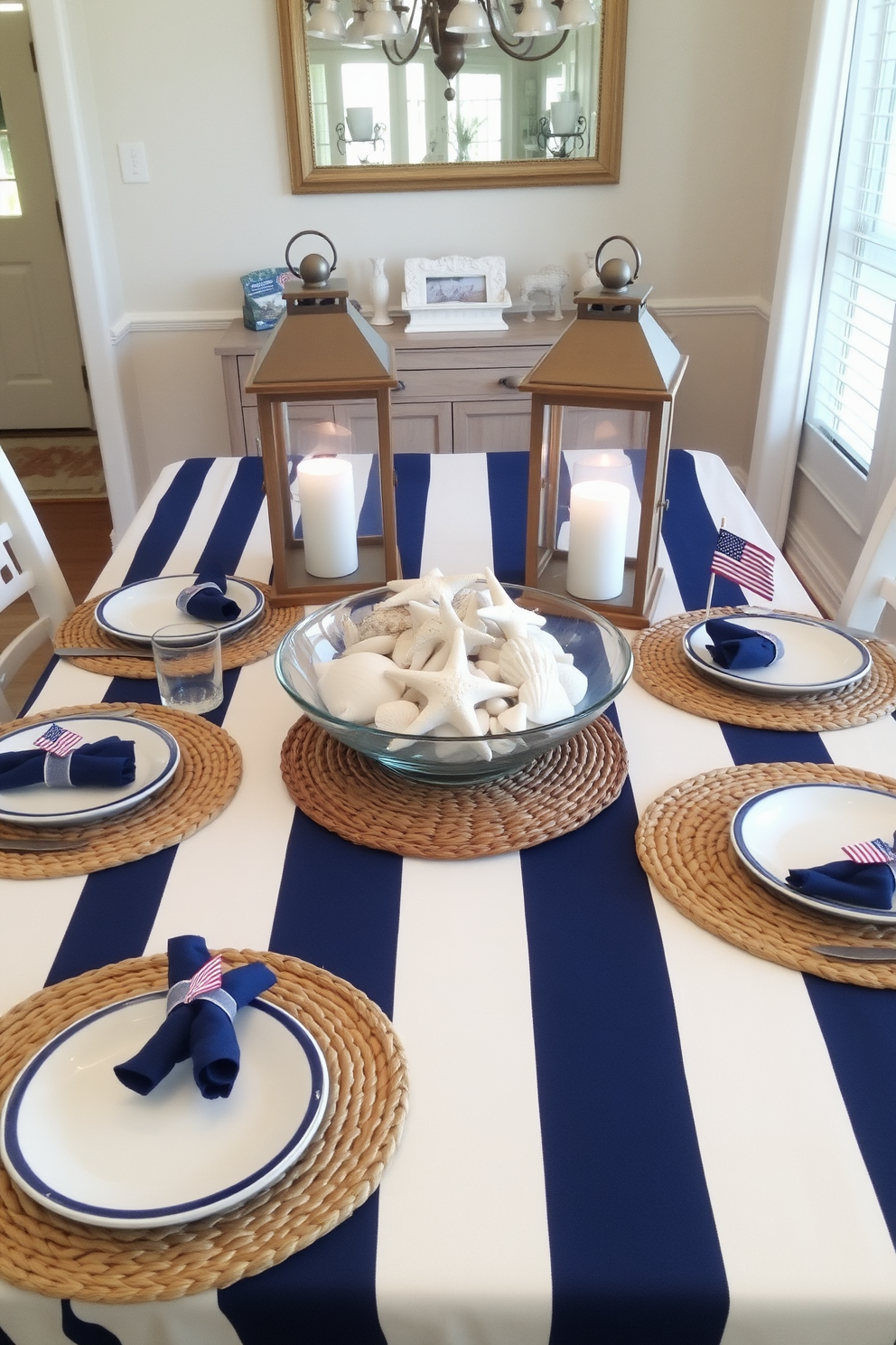 A nautical inspired dining room features a beautifully set table adorned with navy blue and white striped tablecloth. Centered on the table is a collection of seashells and starfish arranged in a glass bowl, complemented by rustic lanterns casting a warm glow. Each place setting includes white dishes with blue trim, paired with woven placemats that evoke a beachy feel. To enhance the theme, small flags and nautical-themed napkin rings are used, creating a charming coastal ambiance for Memorial Day celebrations.