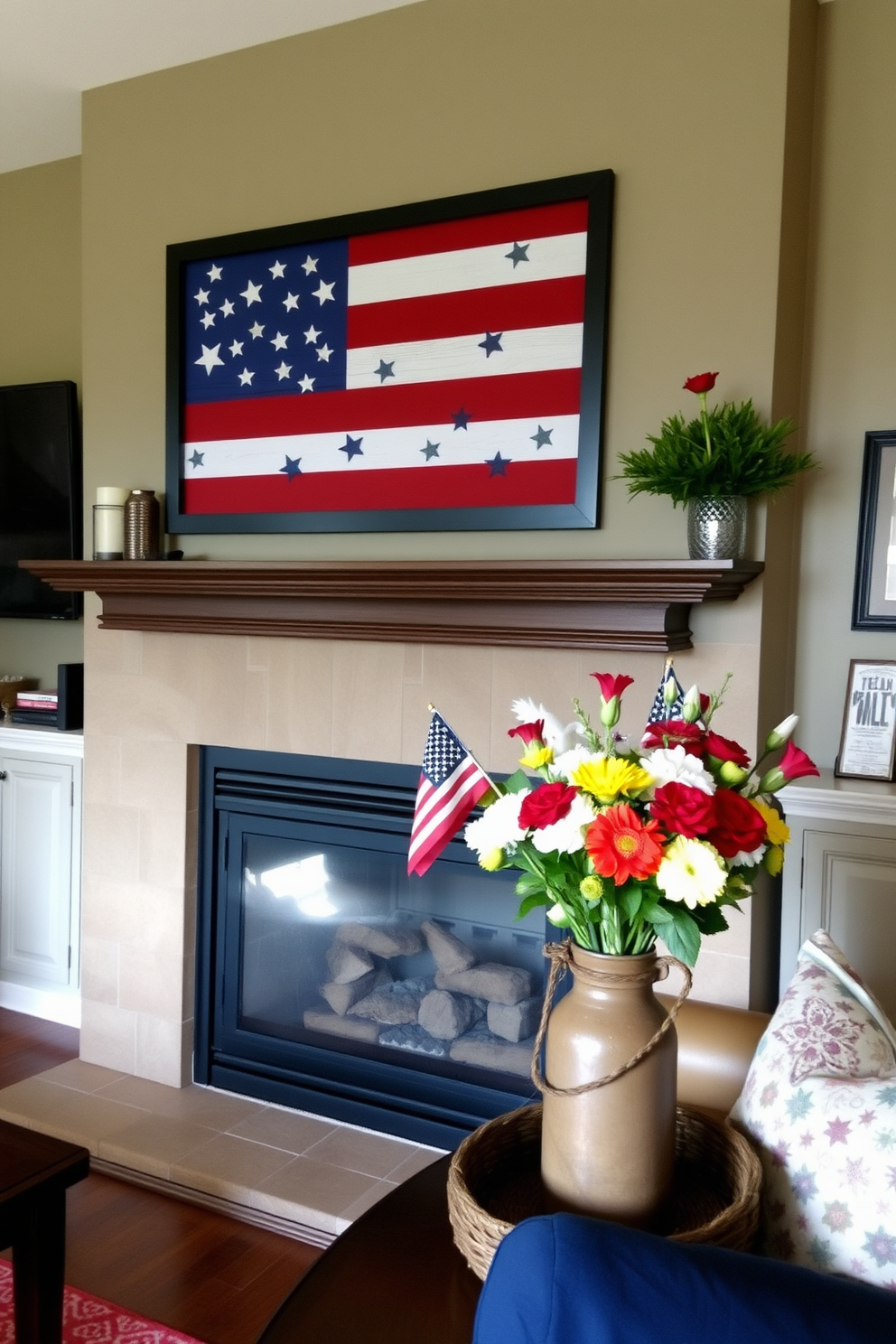 A cozy living room setting adorned with layered textiles featuring patriotic patterns. The sofa is draped with a red and white striped throw blanket and accented with blue star-patterned cushions. In front of the fireplace, a rustic wooden mantel displays seasonal decorations. A collection of small American flags and a wreath made of red, white, and blue flowers create a festive atmosphere.