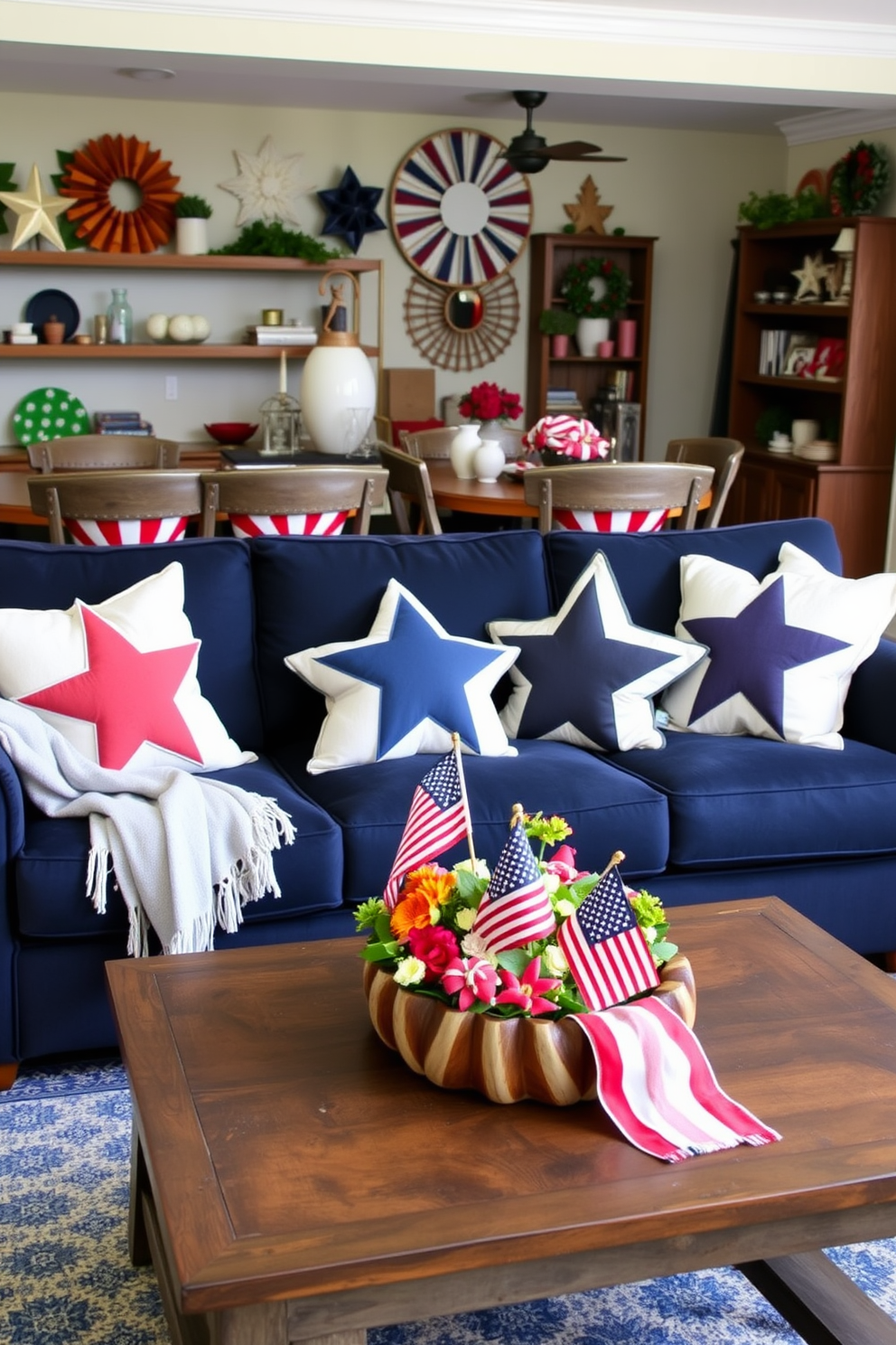 A cozy living room adorned with star shaped decorative pillows in various sizes and colors. The pillows are arranged on a plush navy sofa, complemented by a light gray throw blanket draped casually over one armrest. In the background, a festive Memorial Day theme is created with red, white, and blue accents throughout the space. A rustic coffee table holds a centerpiece of small American flags and seasonal flowers, enhancing the patriotic atmosphere.