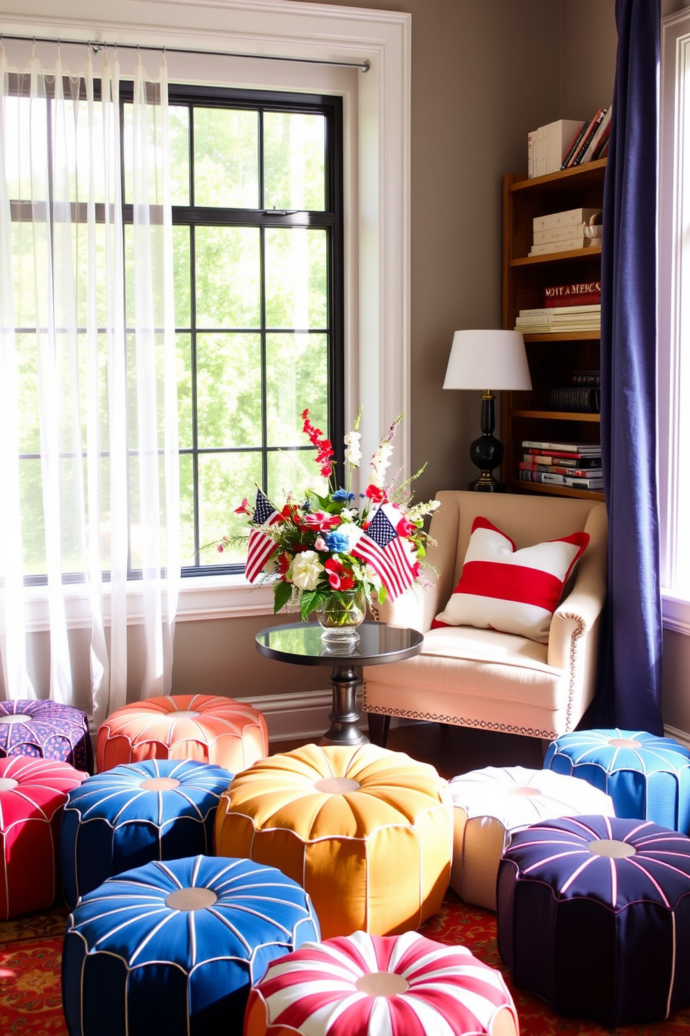 Colorful poufs are scattered around a cozy reading nook providing extra seating options. The space is filled with natural light from a large window adorned with sheer curtains, creating an inviting atmosphere. Memorial Day decorating ideas feature red, white, and blue accents throughout the nook. A plush armchair is paired with a small side table, topped with a festive centerpiece of seasonal flowers and patriotic decor.