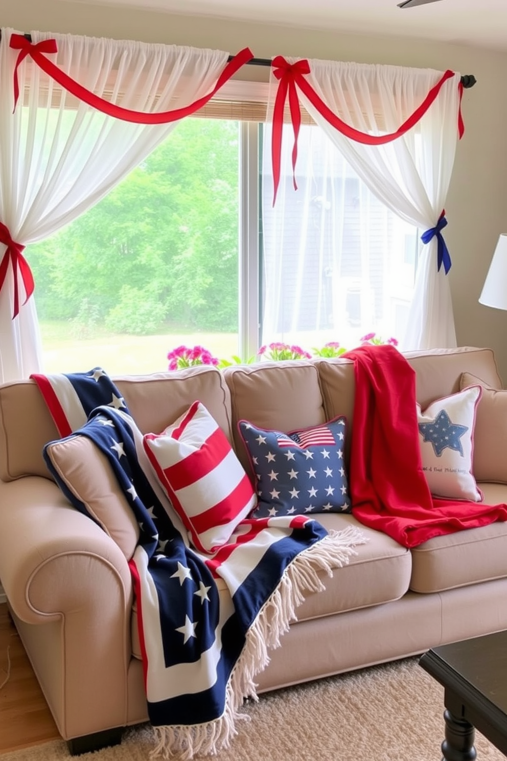 Seasonal throw blankets in patriotic colors are draped over a plush, neutral-toned sofa, adding a festive touch to the living room. The space is accented by decorative pillows featuring stars and stripes, creating a cozy yet spirited atmosphere. For Memorial Day window decorating ideas, sheer white curtains flutter gently in the breeze, complemented by red and blue ribbons tied around the curtain rods. Potted flowers in vibrant hues sit on the windowsill, enhancing the patriotic theme and inviting the outdoors in.