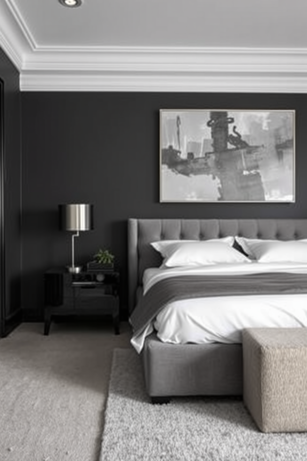 A stylish men's bedroom featuring a monochromatic color scheme that exudes sophistication. The walls are painted in a deep charcoal gray, complemented by a plush gray upholstered bed with crisp white linens. A sleek black nightstand holds a modern lamp with a metallic finish, while a large abstract painting in varying shades of gray adorns the wall above. The floor is covered with a soft area rug in a lighter gray tone, adding warmth to the space.