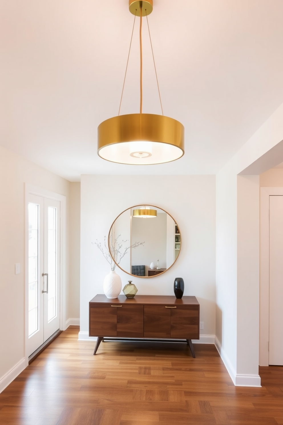 A welcoming foyer featuring layered textures with soft throw pillows in various shades of blue and cream. The space is adorned with a sleek console table made of walnut wood, complemented by a large round mirror with a brass frame above it. Natural light floods in through a large window, illuminating the rich wood flooring and the elegant area rug beneath. A vibrant potted plant adds a touch of greenery, creating a warm and inviting atmosphere.