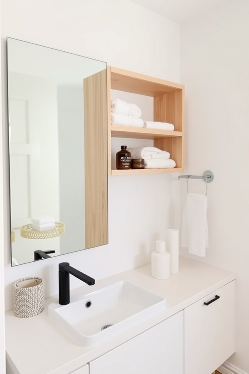 Open shelving for easy access storage creates a clean and organized look in a minimalist bathroom. The shelves are made of light wood, displaying neatly folded towels and a few decorative items, contributing to a serene atmosphere. The walls are painted in a soft white, enhancing the feeling of spaciousness. A sleek, modern sink sits below a large mirror, reflecting the simplicity and elegance of the design.