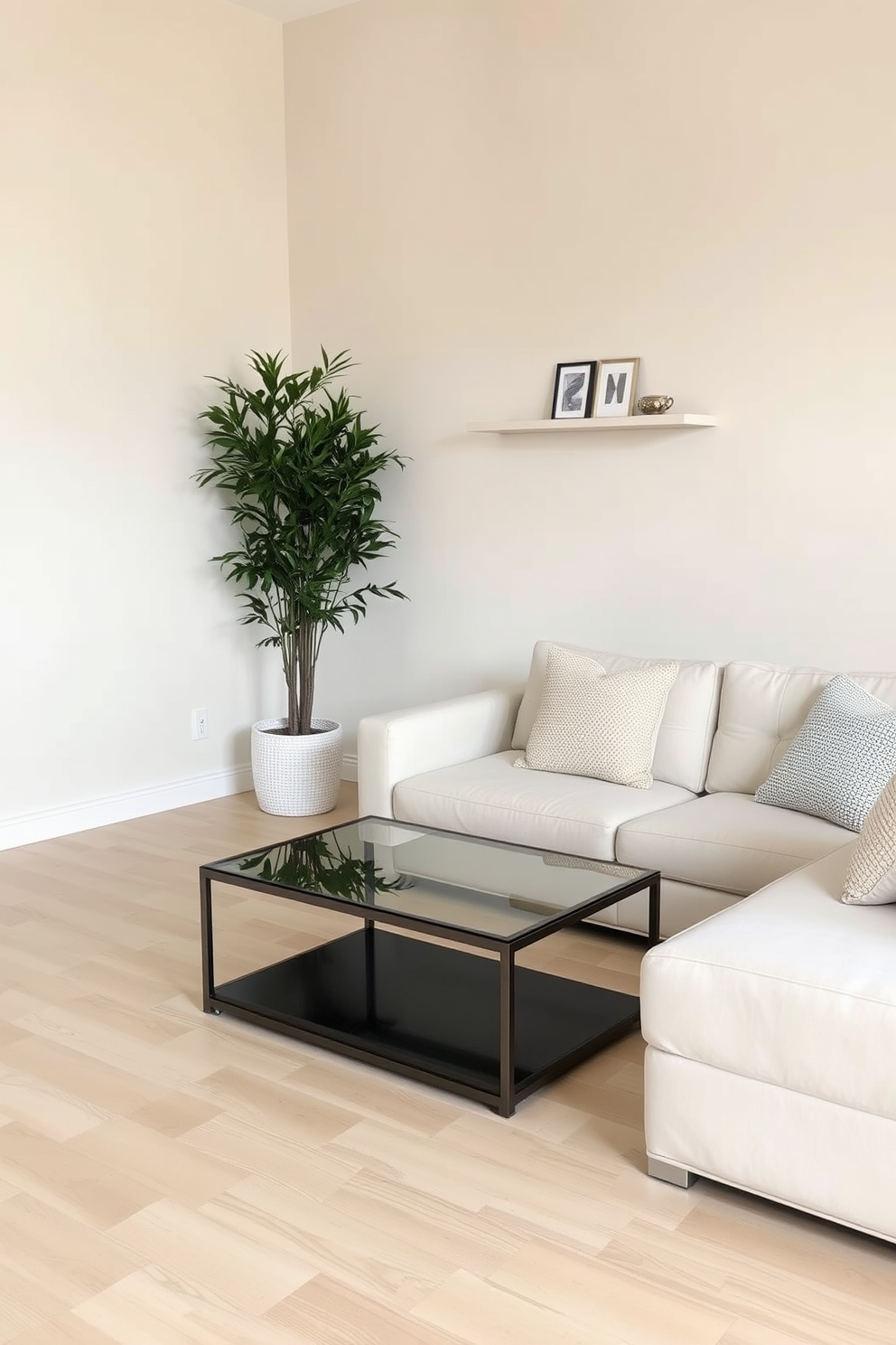 A minimalist family room featuring a neutral color palette with soft beige walls and a light wood floor. The space includes a low-profile sectional sofa adorned with textured throw pillows and a simple coffee table made of glass and metal. In one corner, a tall indoor plant adds a touch of greenery while maintaining the uncluttered aesthetic. Shelves on the wall hold a few carefully chosen decorative items, emphasizing simplicity and tranquility.