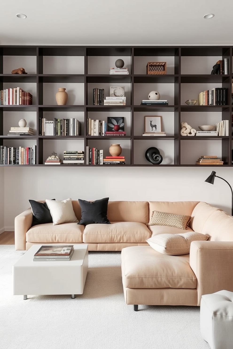 Open shelving for minimalist display. The shelves are filled with carefully curated books and decorative objects, creating a clean and organized look. Minimalist family room design ideas. A large sectional sofa in a neutral color anchors the space, complemented by a simple coffee table and a few accent cushions.