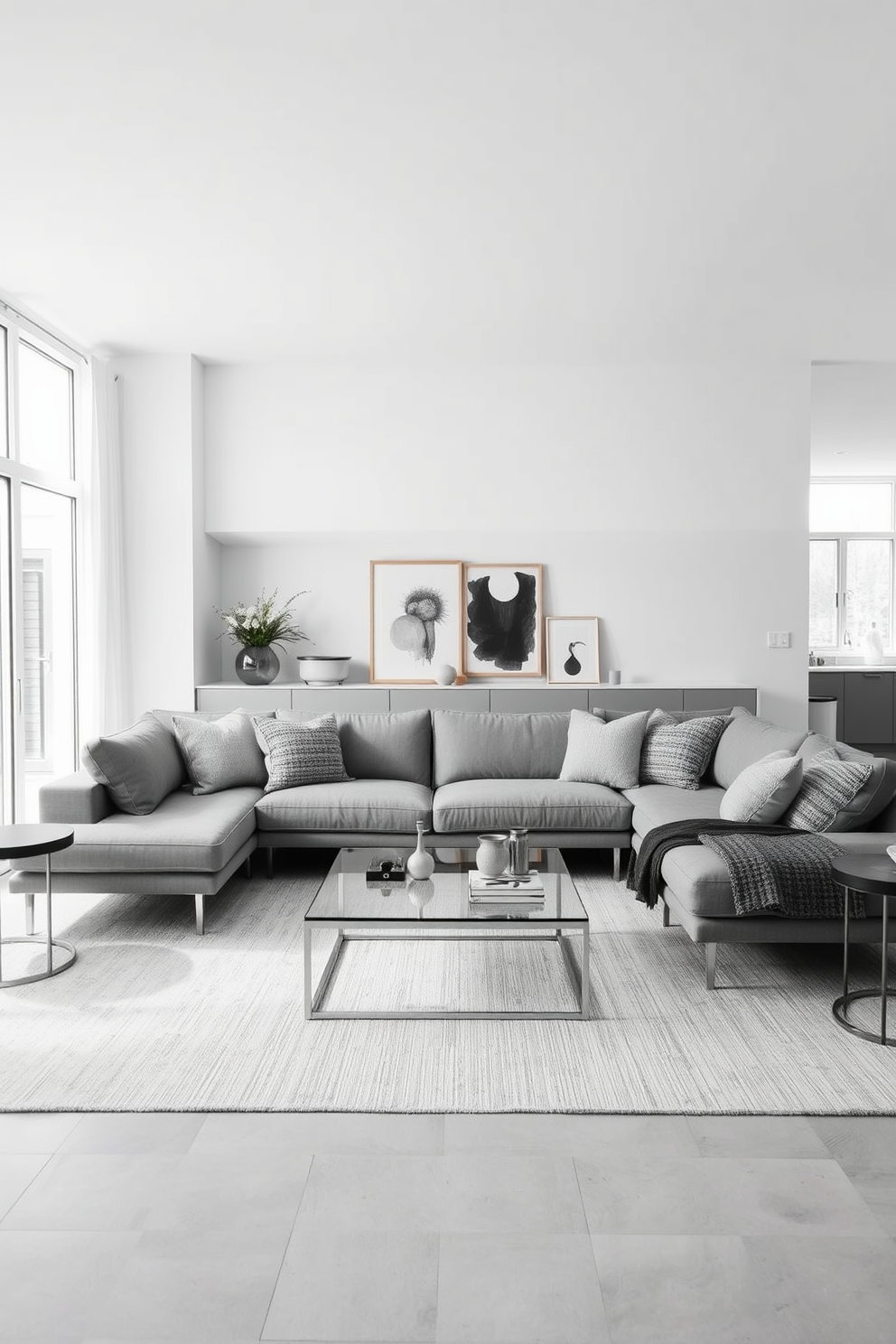 A minimalist family room featuring a monochromatic color scheme with varied shades of gray. The space includes a sleek sectional sofa adorned with textured throw pillows, complemented by a low-profile coffee table made of glass and metal. Natural light floods the room through large windows, highlighting the clean lines of the furniture. A subtle area rug anchors the seating arrangement, while a few curated decorative items add a personal touch without cluttering the space.