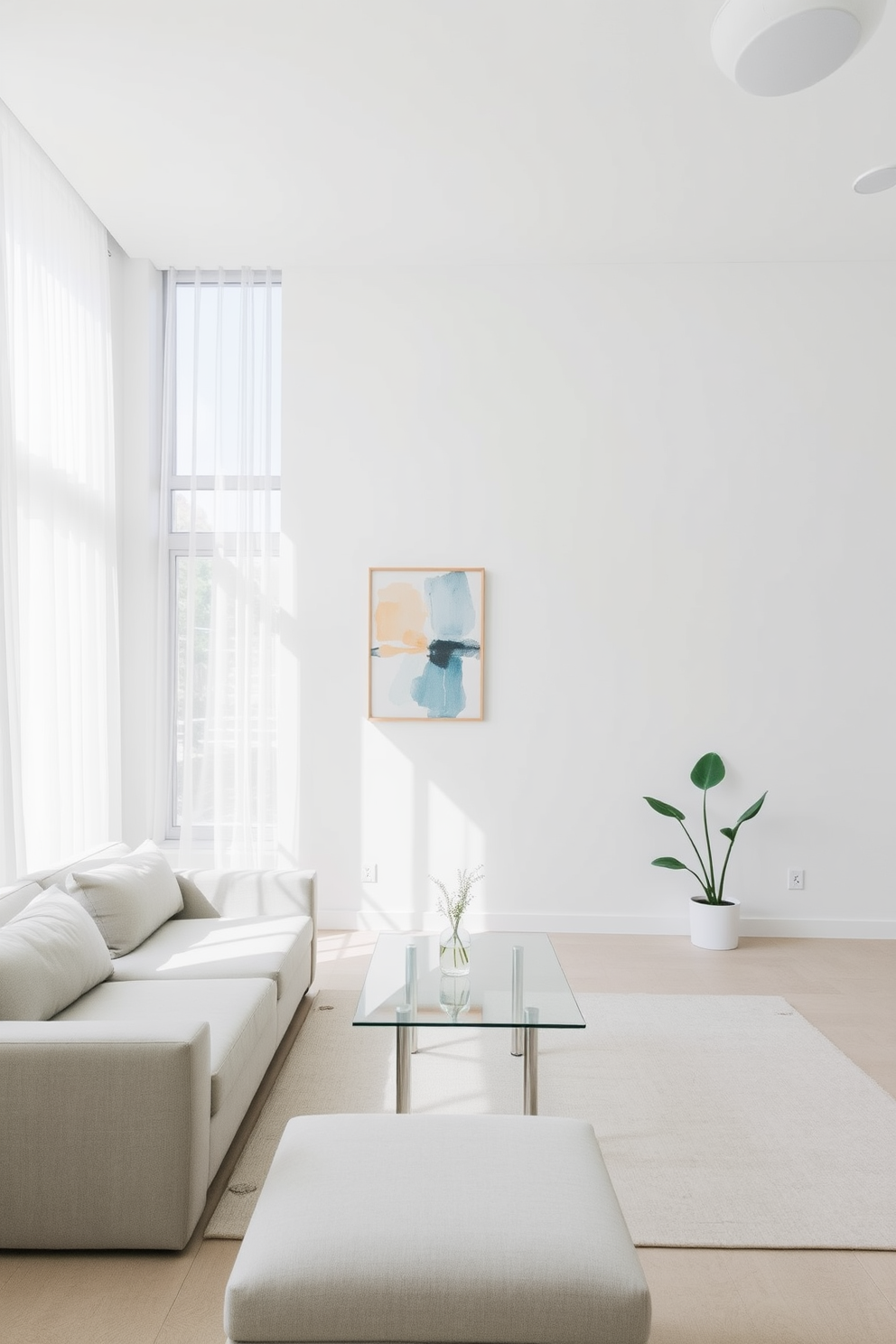 A minimalist living room features a neutral color palette with soft textures and clean lines. A low-profile sofa in light gray is paired with a sleek glass coffee table, while a single piece of abstract art hangs on the wall, adding a pop of color. Natural light floods the room through large windows adorned with sheer curtains. A simple indoor plant sits in the corner, bringing a touch of nature into the serene space.