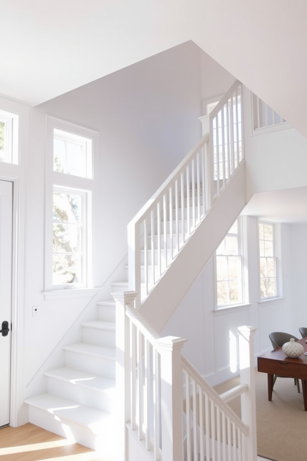 A simple white staircase bathed in natural light creates an inviting focal point in the home. The walls are painted in a soft white, allowing the light to reflect and enhance the airy ambiance. The staircase features sleek, minimalist railings that complement the clean lines of the design. Large windows nearby flood the space with sunlight, highlighting the elegant simplicity of the staircase.