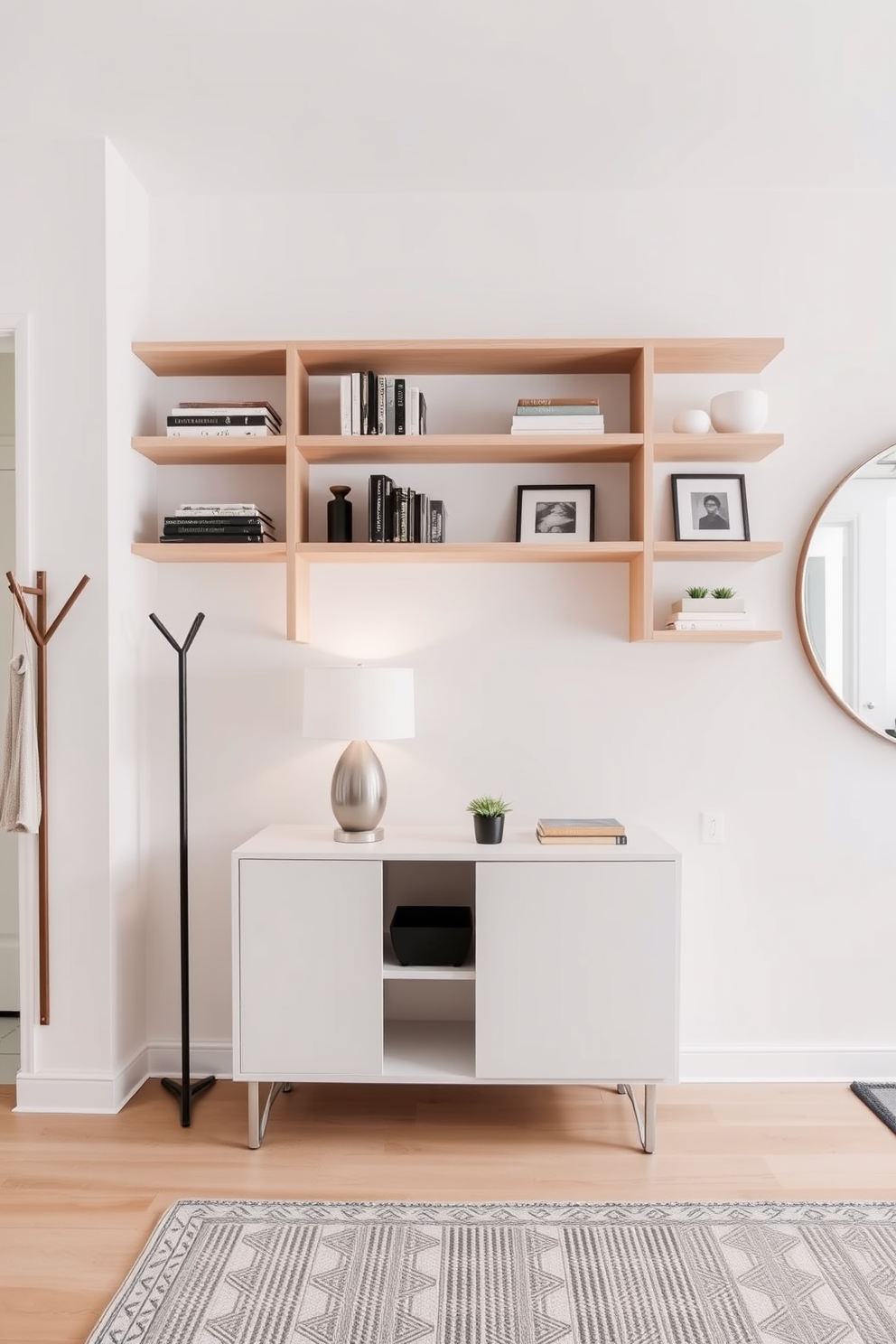 Open shelving is elegantly arranged in a modern entryway, showcasing a curated selection of decorative accents such as books, vases, and framed photos. The shelves are made of light wood and are complemented by a sleek console table beneath them, adorned with a stylish lamp and a small indoor plant. The entryway features a minimalist coat rack and a large round mirror that enhances the sense of space. Soft, neutral tones on the walls and a textured area rug add warmth and invite guests into this stylish and functional space.