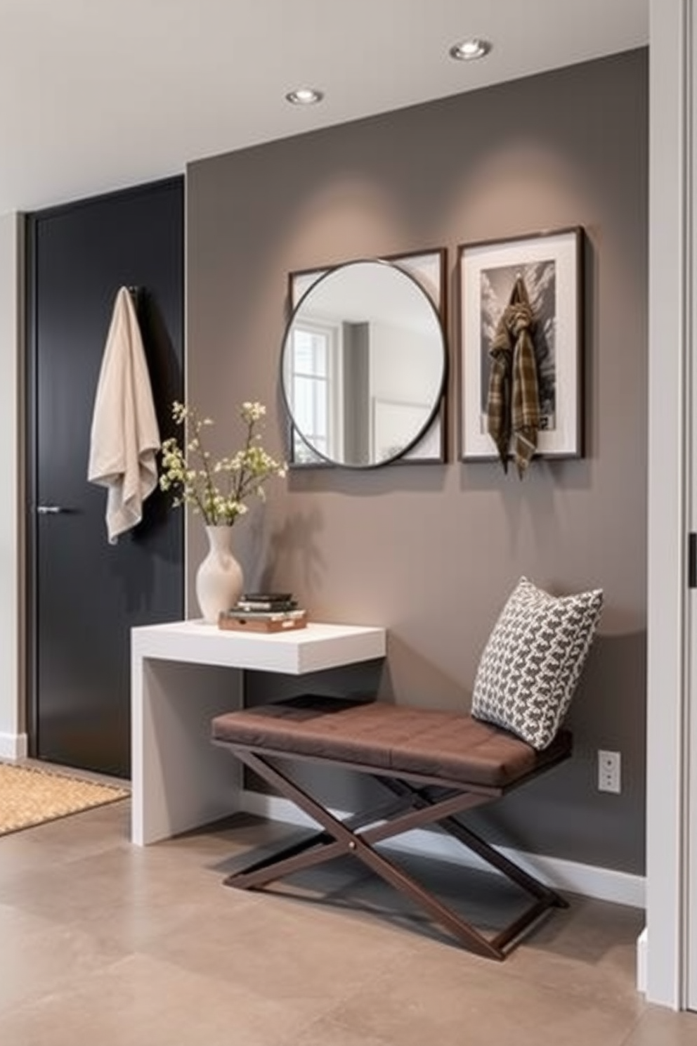 A stylish entryway features a sleek shoe storage bench crafted from light oak wood. The bench is paired with a wall-mounted coat rack made of black metal, creating a contemporary contrast. The walls are painted in a soft gray tone, complemented by a geometric patterned rug in muted colors. A large round mirror hangs above the bench, enhancing the sense of space and reflecting natural light.