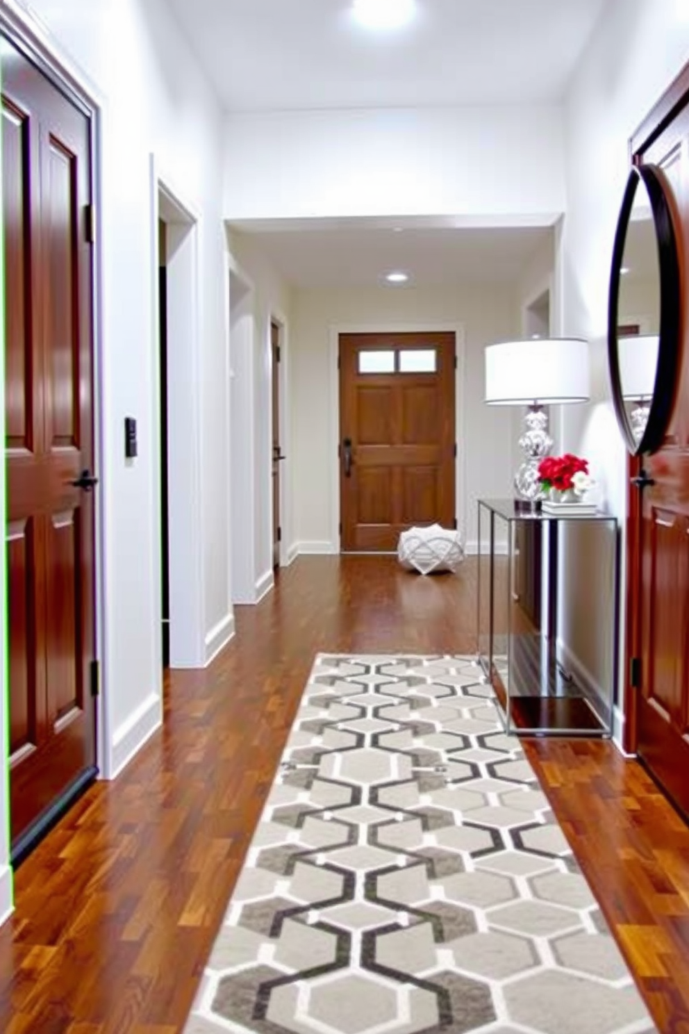 A modern entryway features a geometric patterned runner rug that adds visual interest and warmth to the space. The walls are painted in a crisp white, and a sleek console table sits against one side, adorned with decorative items and a stylish lamp.