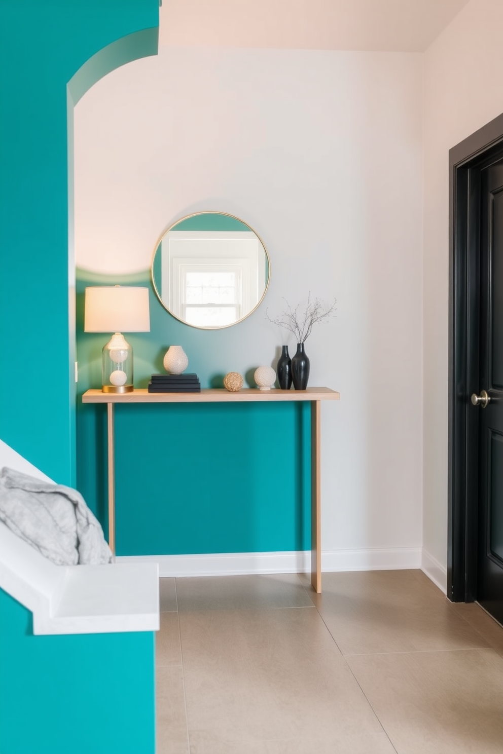 A striking accent wall painted in a vibrant teal creates a bold focal point in the entryway. Complementing the wall, a sleek console table in a light wood finish sits against it, adorned with a stylish lamp and a few decorative items. The flooring features large format tiles in a neutral tone that enhance the overall brightness of the space. A round mirror with a thin gold frame hangs above the console table, reflecting natural light and adding depth to the entryway.