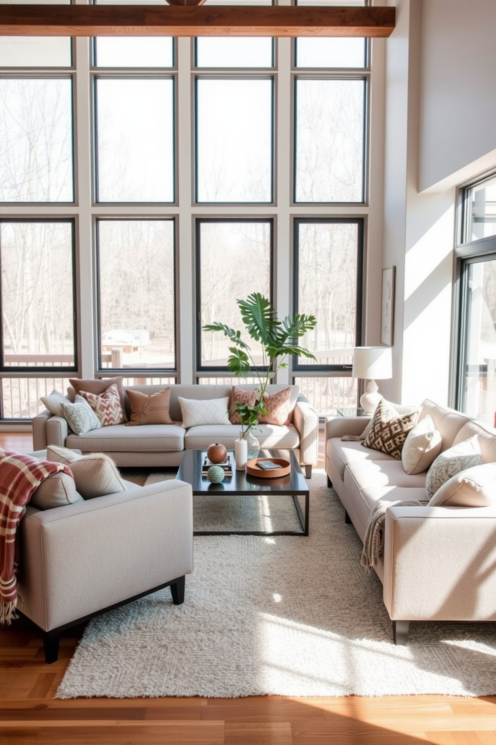 A modern family room featuring soft textiles for added comfort. Plush sofas in neutral tones are arranged around a sleek coffee table, with cozy throw blankets draped over the arms. Large windows allow natural light to flood the space, highlighting the warm wood flooring. Decorative cushions in various textures and patterns are scattered across the seating for a welcoming touch.