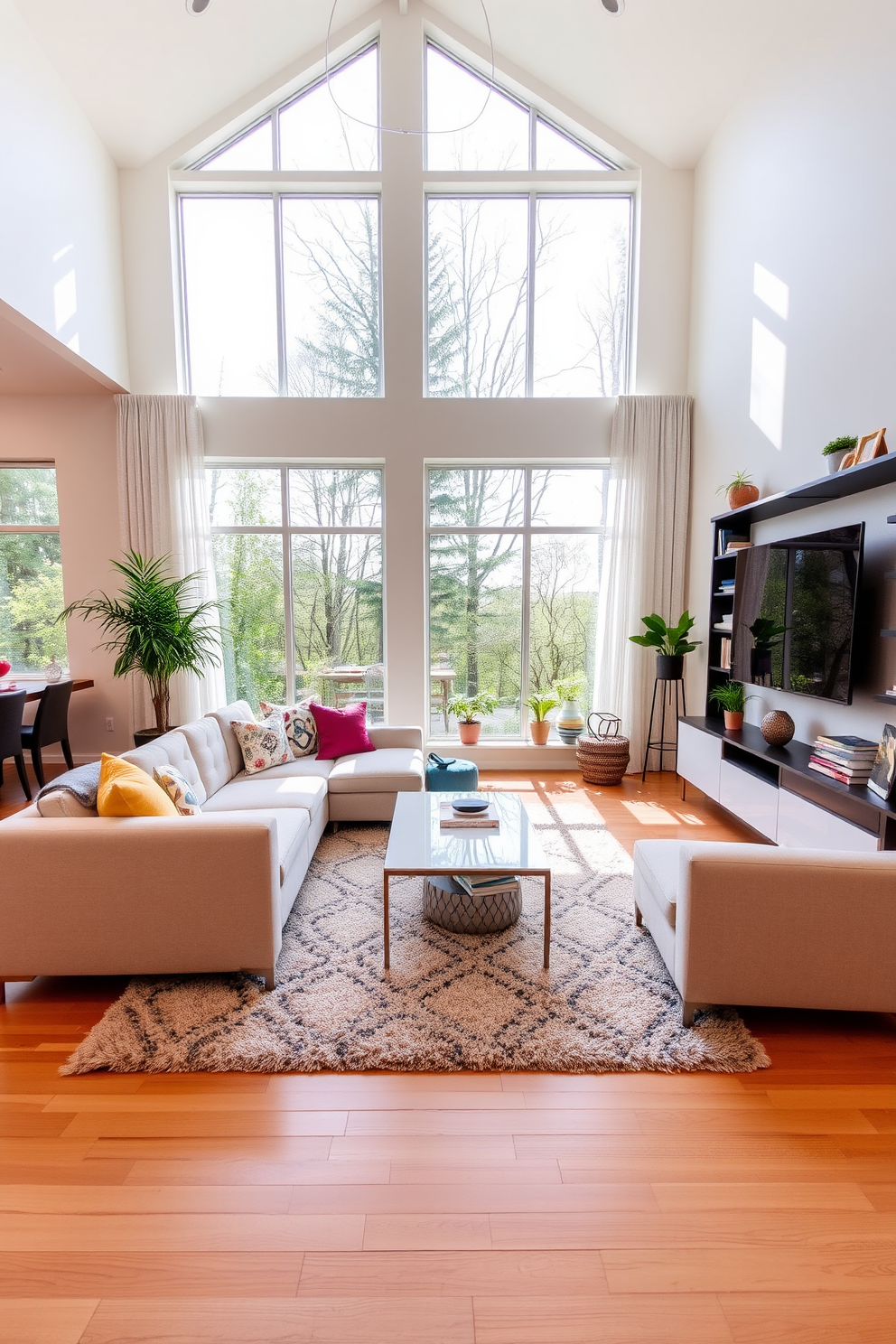 A spacious family room filled with natural light streaming in through large floor-to-ceiling windows. The room features a cozy sectional sofa in soft neutral tones paired with vibrant accent pillows and a stylish coffee table at the center. A contemporary entertainment unit is mounted on the wall, showcasing a sleek television and decorative shelves filled with books and plants. The flooring is a warm hardwood, complemented by a plush area rug that adds comfort and texture to the space.