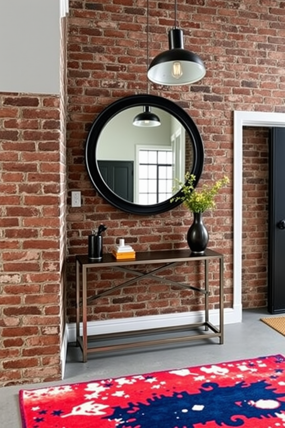 A modern foyer featuring industrial elements. Exposed brick walls create a rustic backdrop while a sleek metal console table adds contemporary flair. A large round mirror with a black frame hangs above the table, reflecting the light from a stylish pendant lamp. The floor is adorned with polished concrete, complemented by a vibrant area rug that introduces warmth and color.